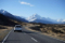 Car driving on a highway with majestic snow-capped mountains in the distance